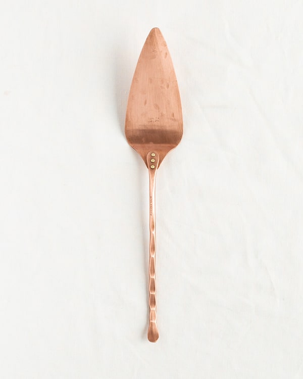 A handmade cake server on a white background. 