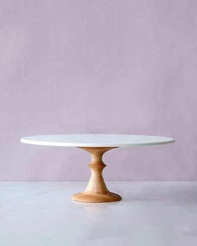 A cake stand against a purple wall. 