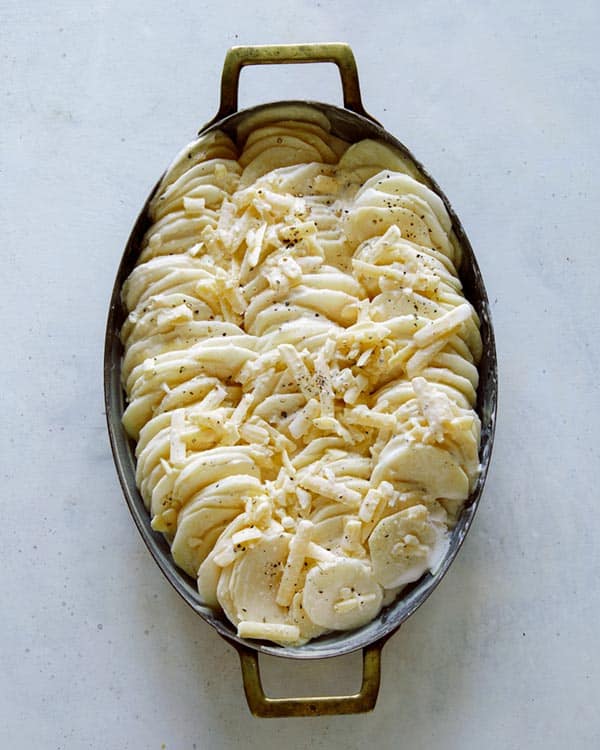 Potatoes gratin in a casserole dish before its baked.