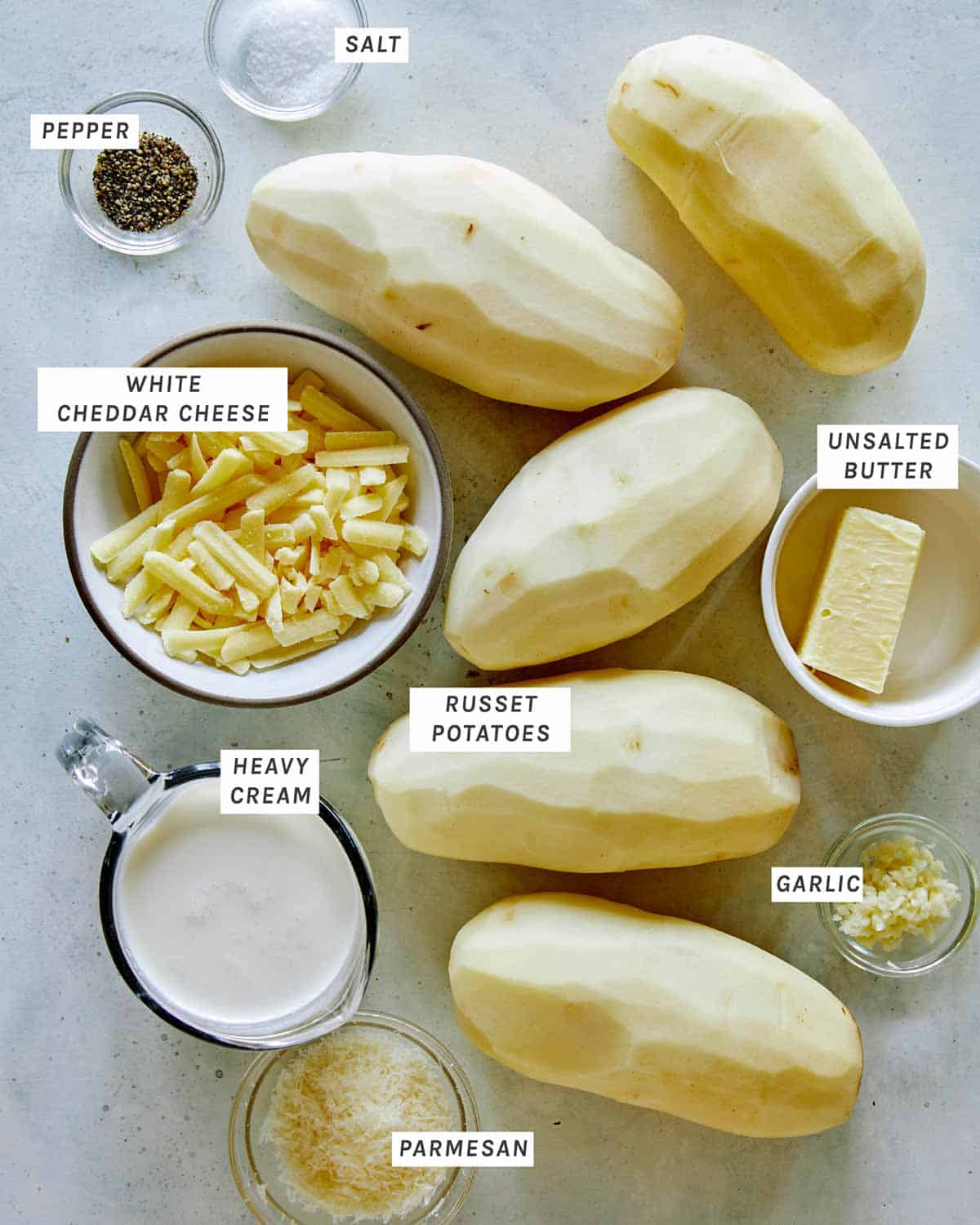 Ingredients for a cheesy potato gratin all laid out on a kitchen counter. 