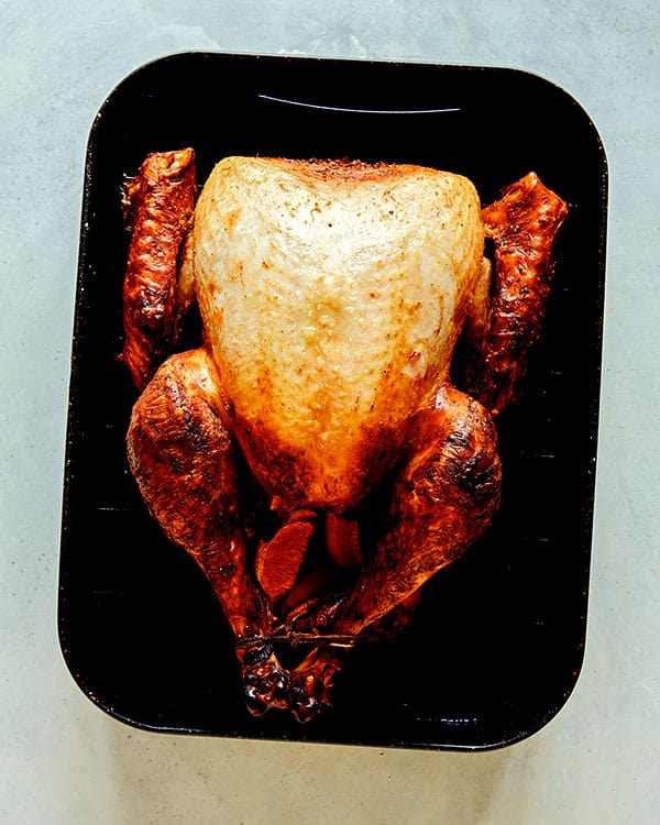A turkey in a roasting pan being roasted. 