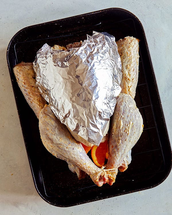 A turkey with a breast covered in tin foil. 