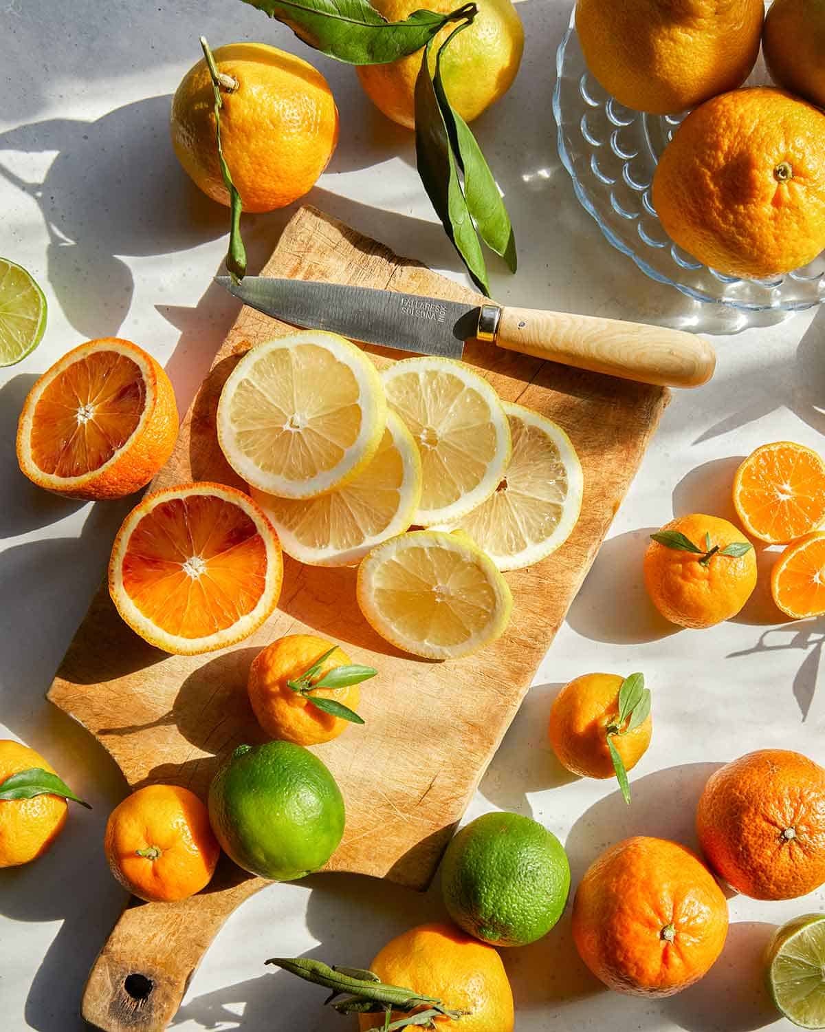 Slicing various kinds of citrus to make dehydrated citrus wheels.