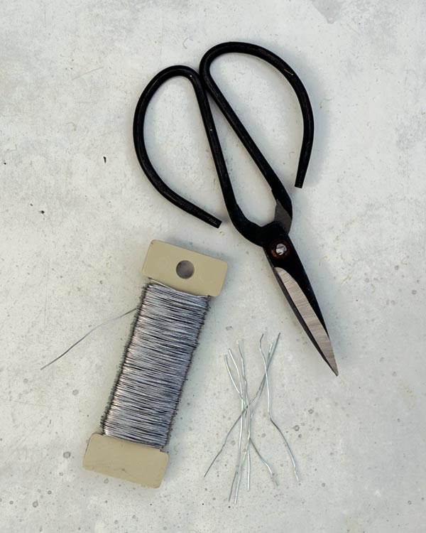 Floral wire cut into six short lengths with scissors next to it. 