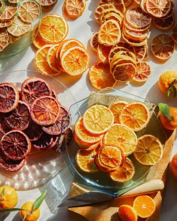 Dehydrated citrus on a surface on plates with fresh citrus.