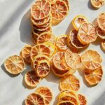 Dehydrated lemon slices spread out on a kitchen counter.