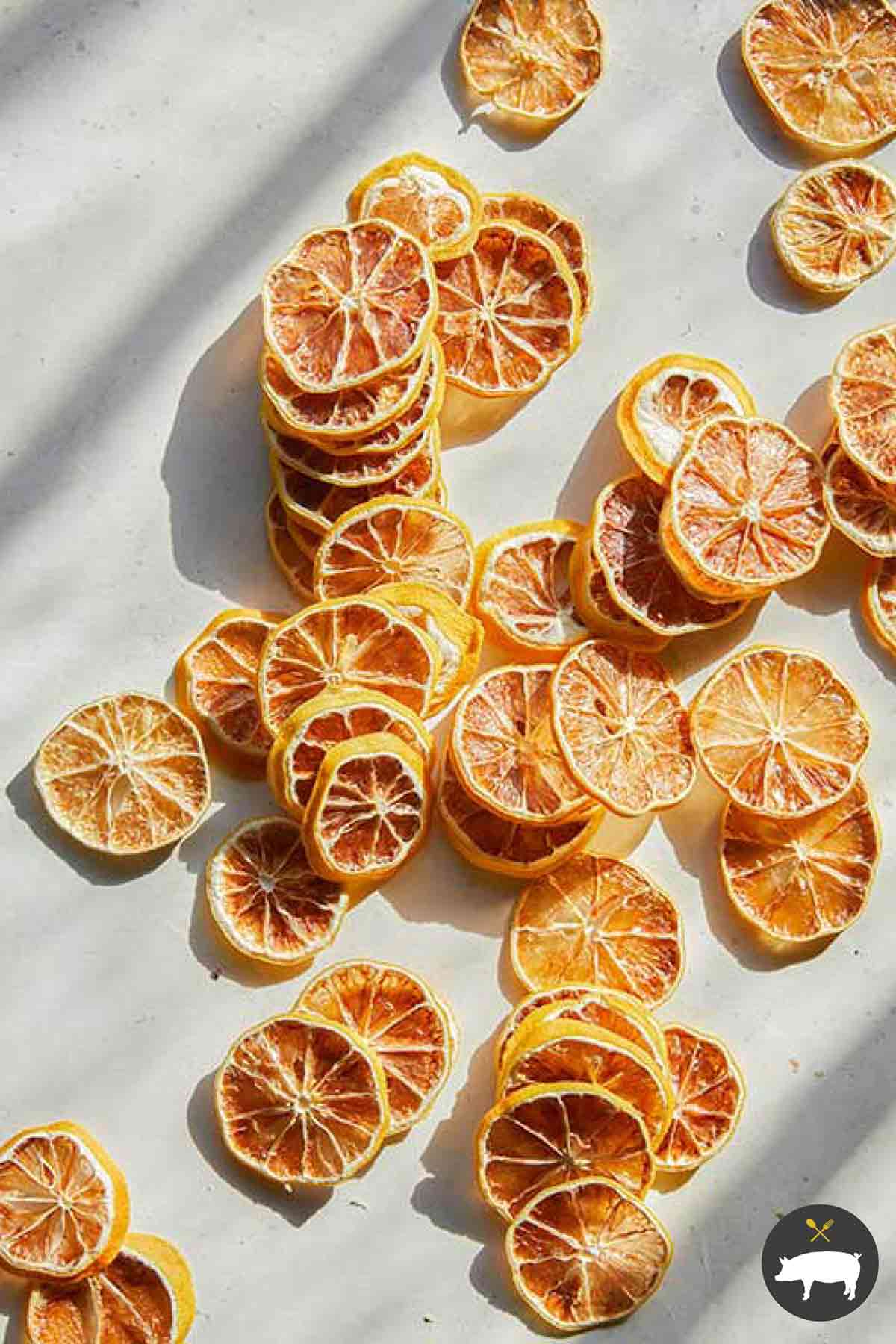 Dehydrated lemon slices spread out on a kitchen counter.