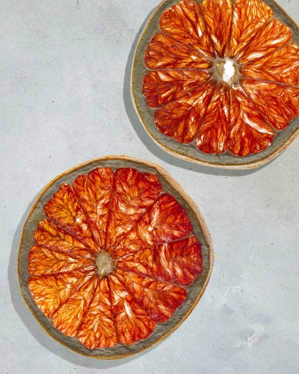 Blood orange slices on a white surface. 