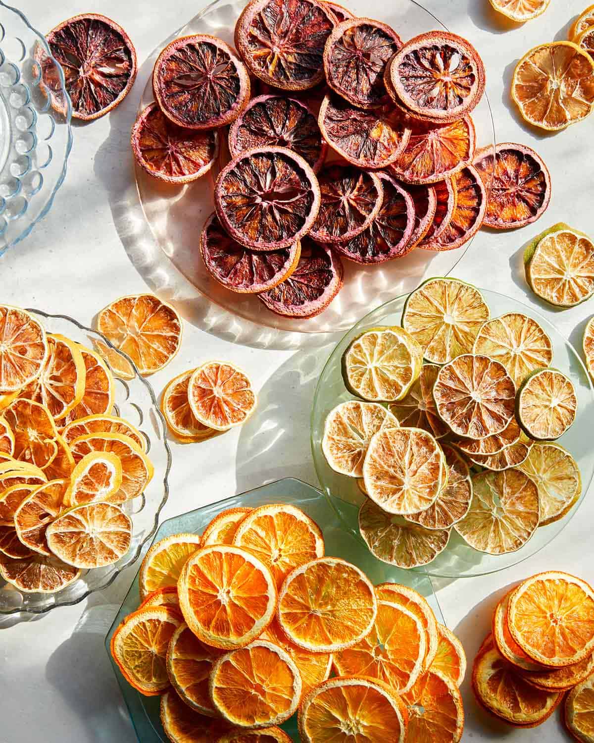 Various typed of dehydrated citrus wheels on a plates.