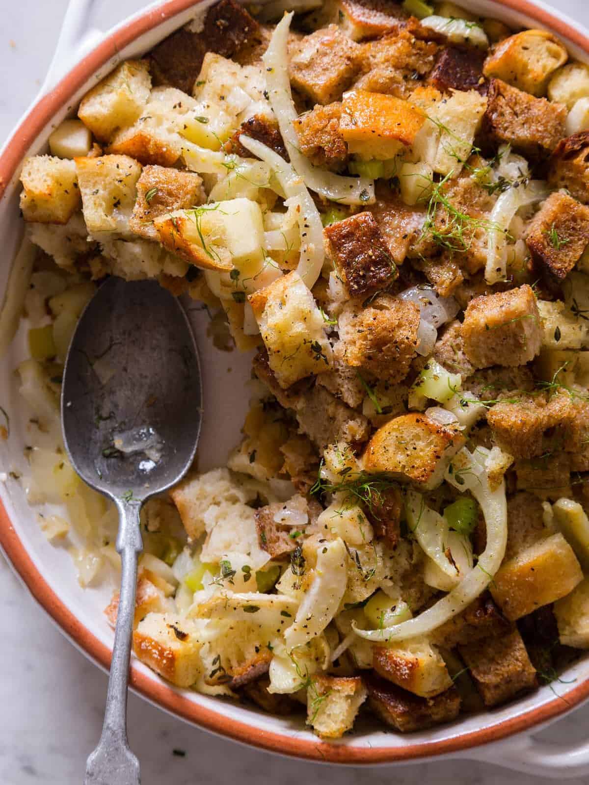 A close up of fennel apple stuffing with a spoon.