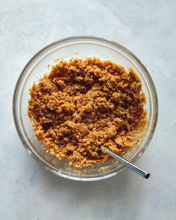 French silk pie crust ingredients in a bowl with a spoon in it. 