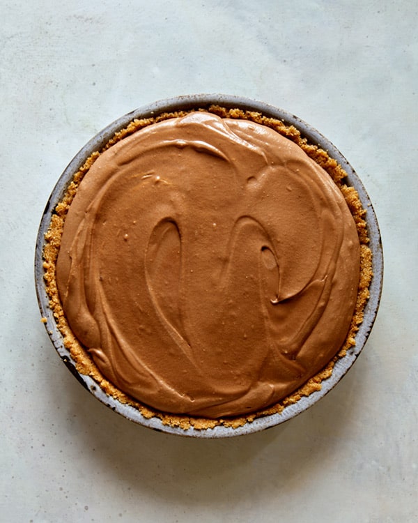 French silk pie in a pie dish waiting for the refrigerator.