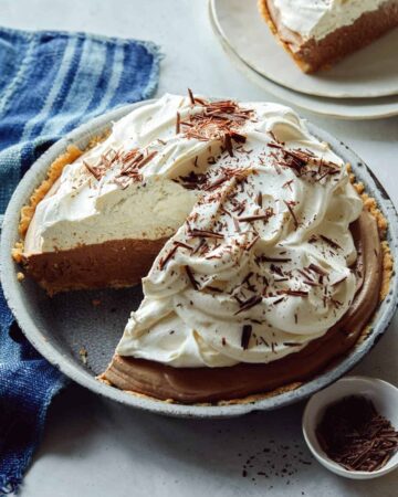 French silk pie with a slice out on a plate next to it.