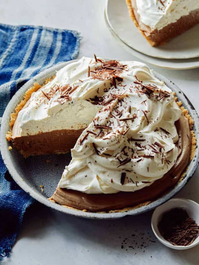 French silk pie in a a pie dish with a slice taken out. 
