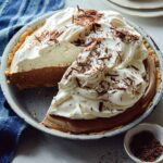 A whole french silk pie with a slice taken out and a piece next to it.