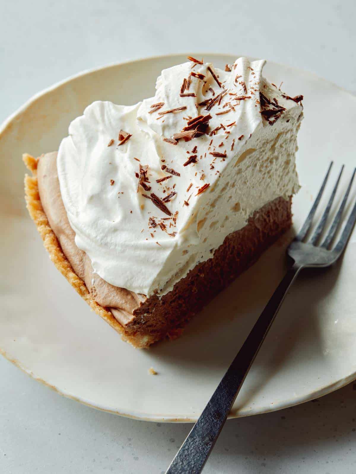 A slice of french silk pie on a plate with a fork next to it. 