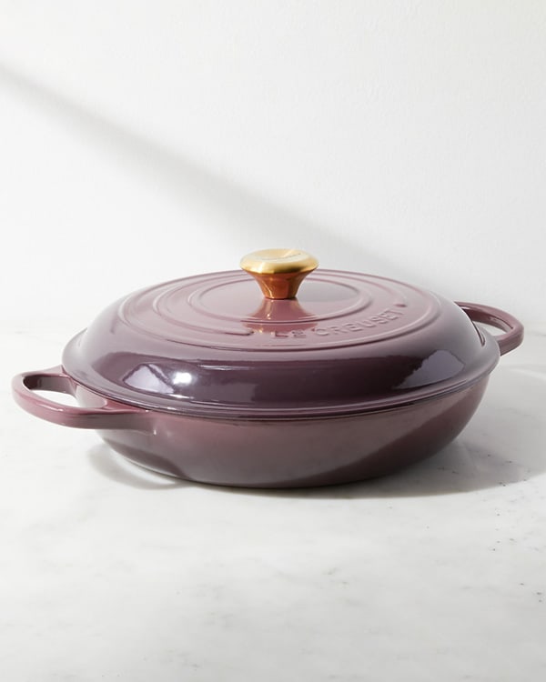 Le Creuset braiser in purple on a marble surface.