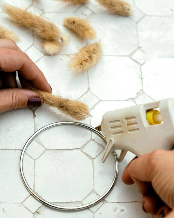 The process of gluing bunny tails on a metal ring.