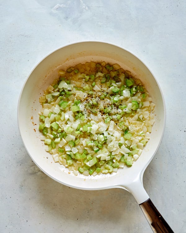 Melt butter and sauté onion, celery and garlic. Season with salt and pepper in a skillet.