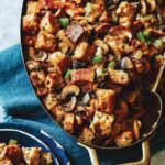 Mushroom and sage stuffing in a baking dish with some in a bowl next to it.