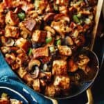 Mushroom and sage stuffing in a baking dish with some in a bowl next to it.