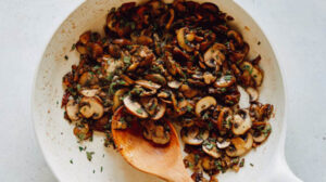 A skillet with mushrooms and herbs.