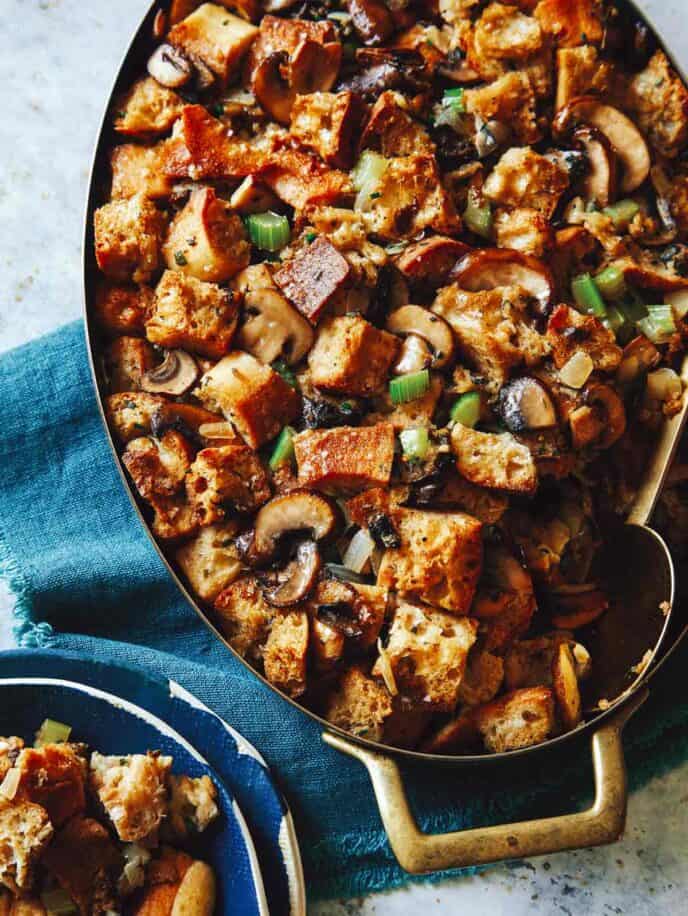 Mushroom and sage stuffing in a baking dish with some in a bowl next to it.