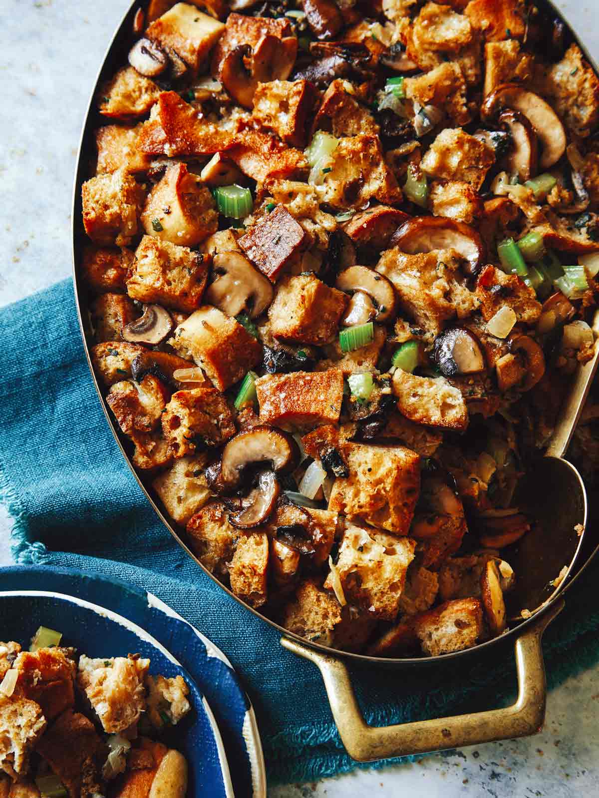 Mushroom and sage stuffing in a baking dish with some in a bowl next to it. 