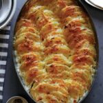 Close up on a casserole dish of cheesy potatoes gratin.