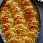 Close up on a casserole dish of cheesy potatoes gratin.