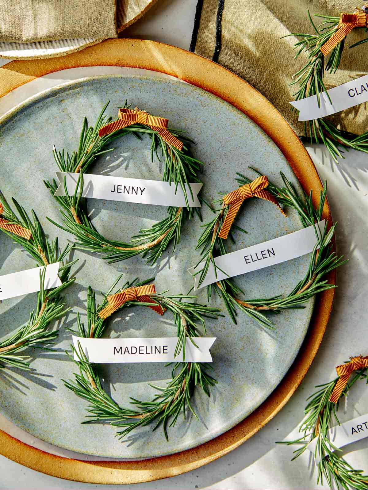 Rosemary wreath place cards with plates and linens. 