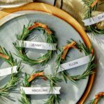 Rosemary wreath place cards with plates and linens.