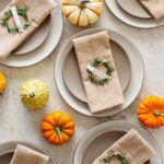 Rosemary wreath place cards on napkins on plates.