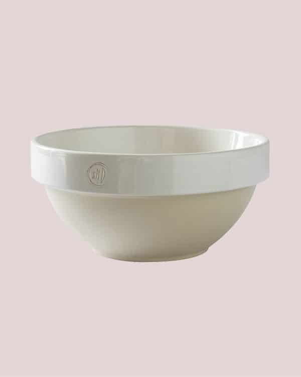 A ceramic french bowl on a peach background. 