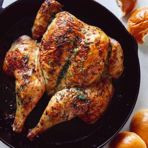 Spatchcock chicken in a skillet freshly roasted.