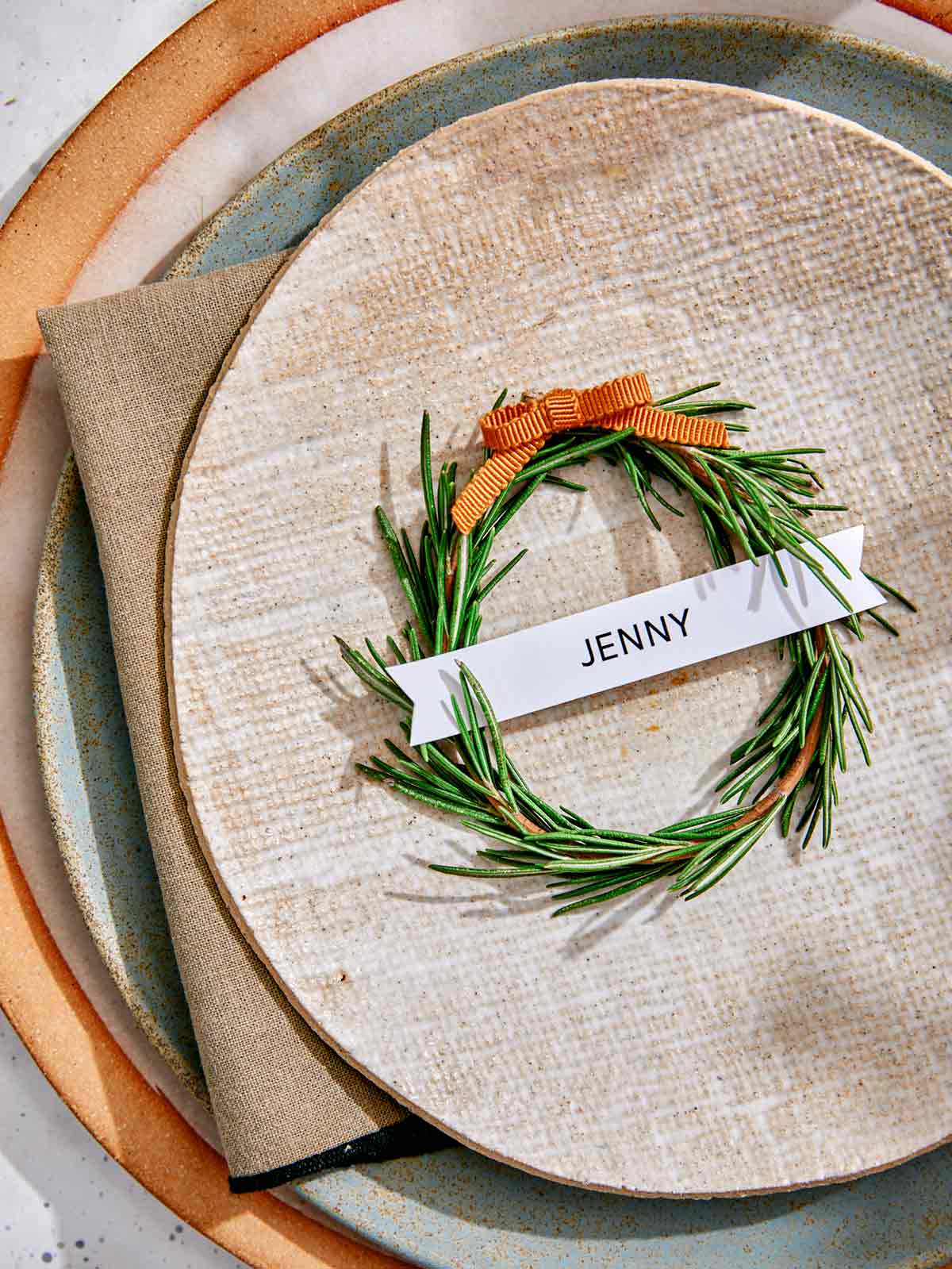 Rosemary wreath place card up close on a plate. 