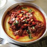 Braised beef ragu in two bowls with forks on the side.