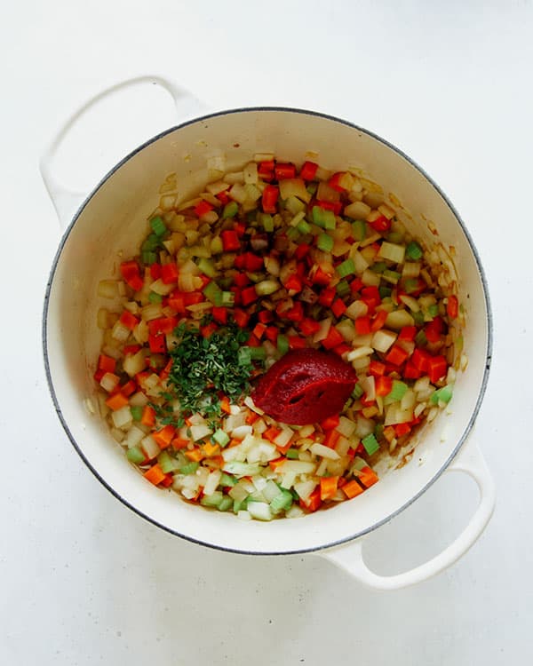 Sauted veg with tomato paste and herbs in a stock pot.