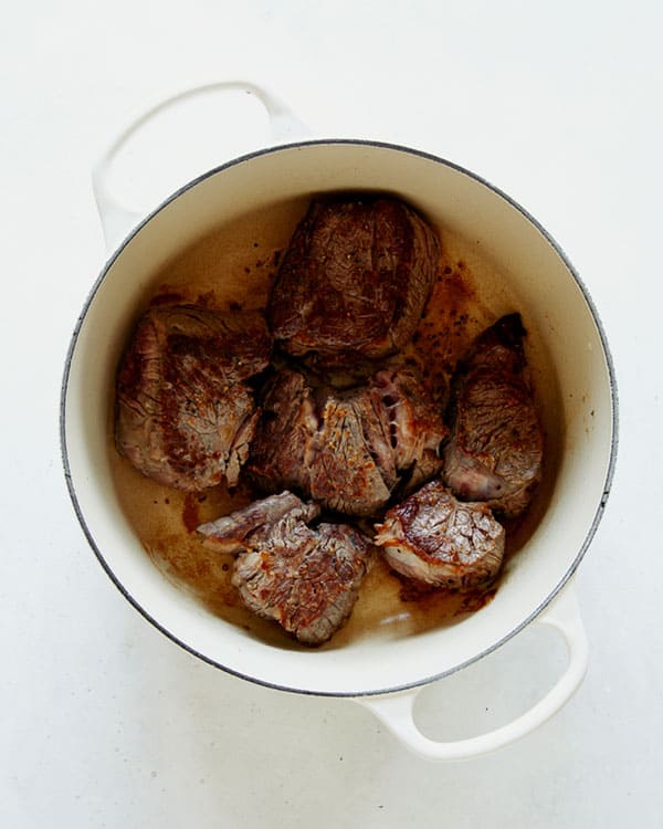 Seared beef in a stock pot overhead.