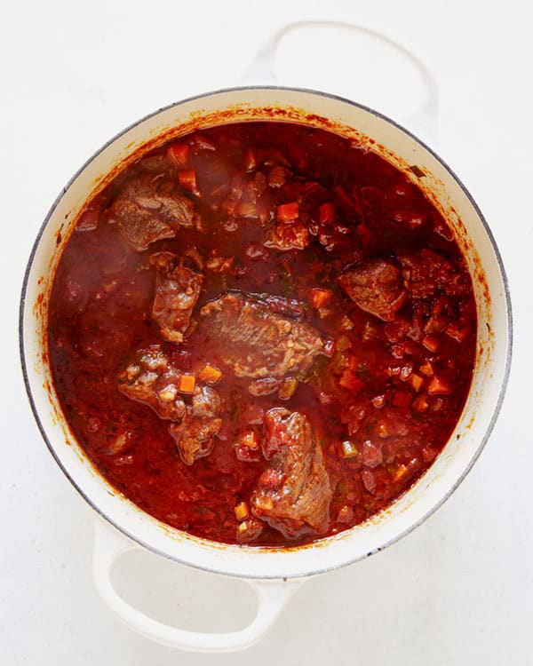 Beef simmering in a stock pot to make beef ragu.