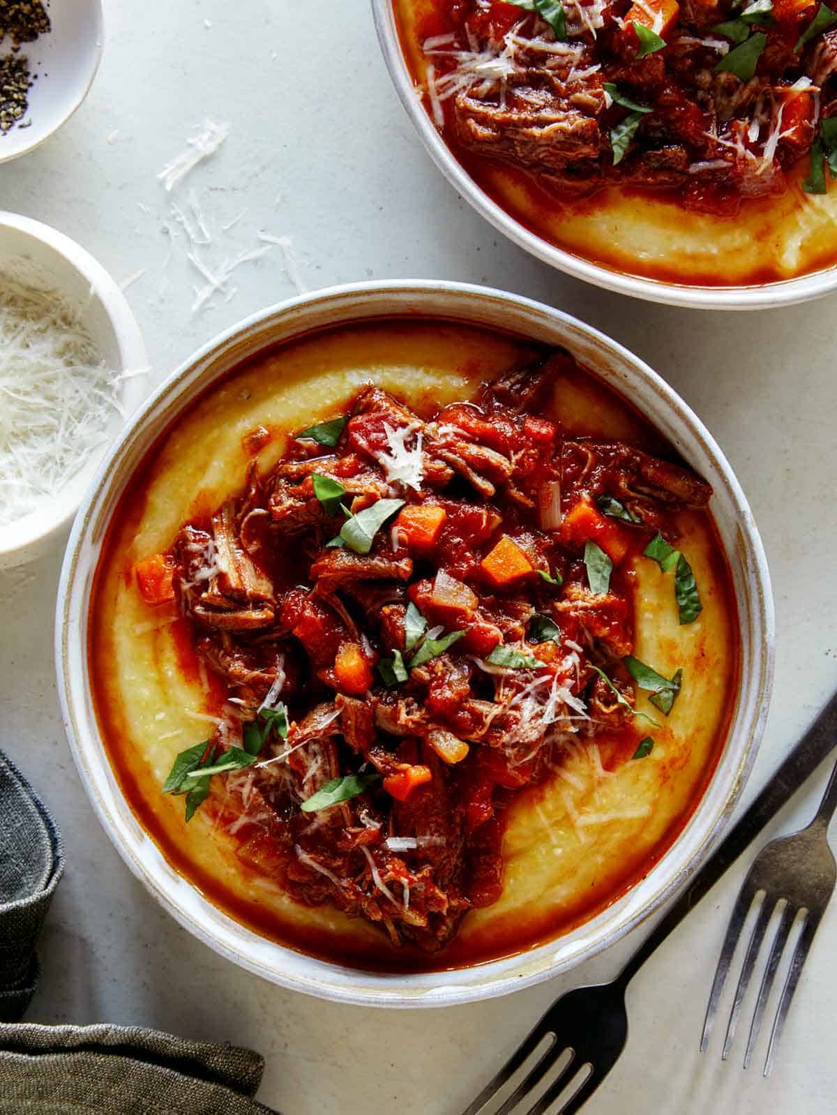 Beef ragu overhead in two bowls with forks.