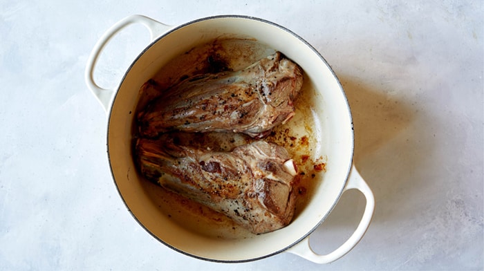 Sear lamb shanks in a stock pot.