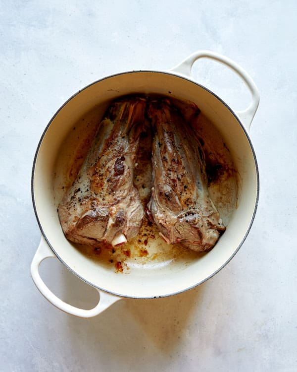 Sear lamb shanks in a stock pot.