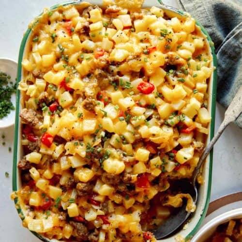 Breakfast casserole with a scoop out and some in a bowl next to it.