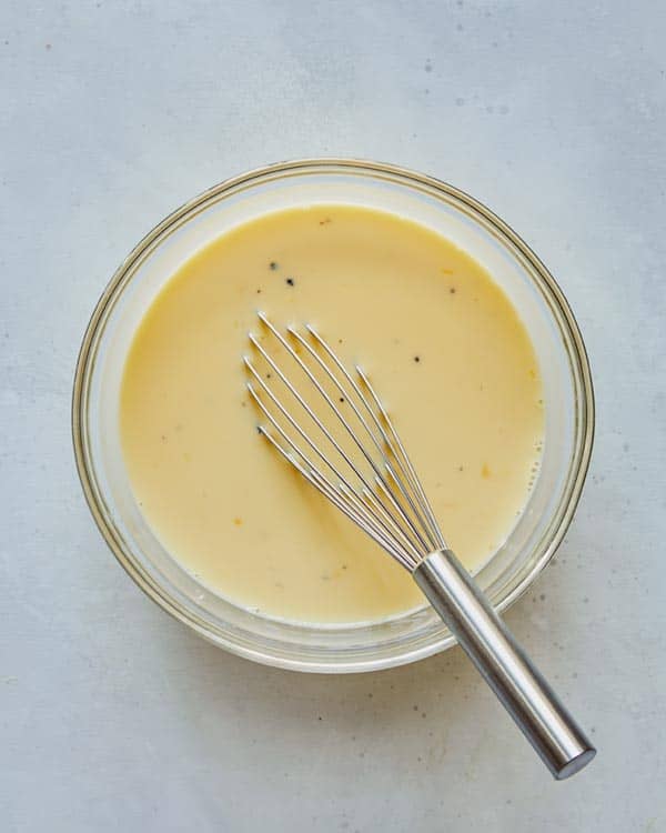 Egg mixture in a glass bowl for breakfast casserole.
