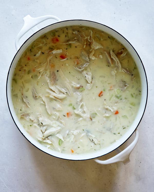 Chicken soup in a pot on a kitchen counter.