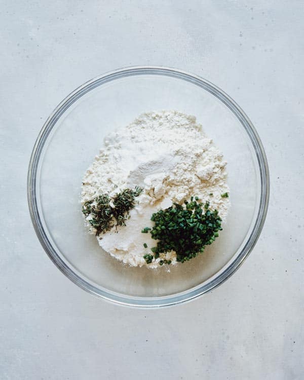 Dry ingredients for dumplings in a glass bowl.