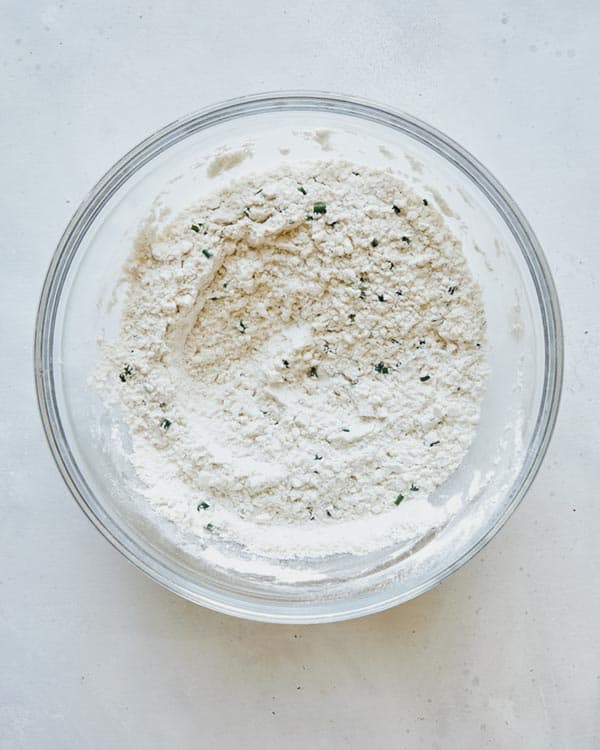 Dry ingredients combined in a glass bowl for dumplings.
