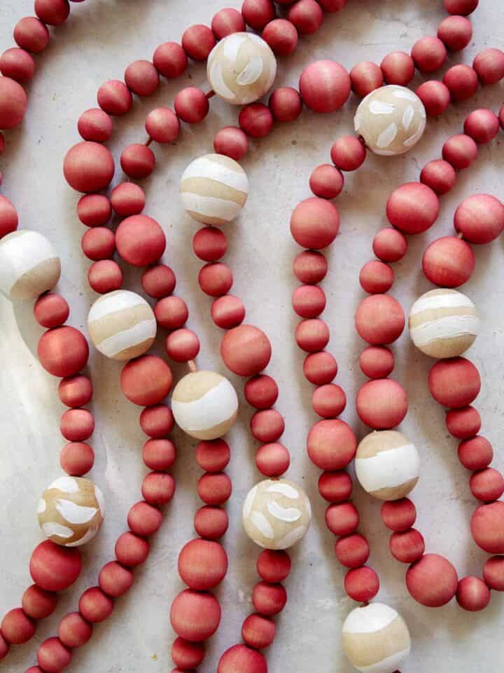 DIY Christmas garland made of wood beans laid out on a surface.