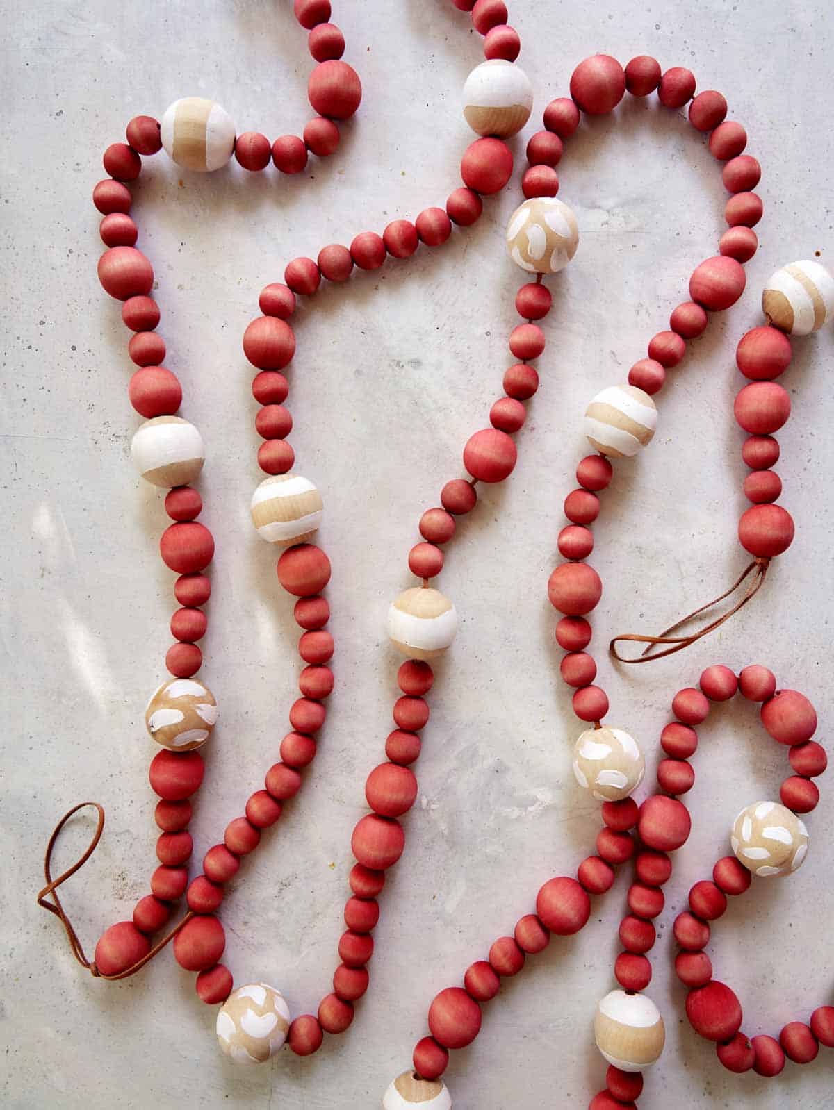 A wood bead garland laid out on a  counter. 